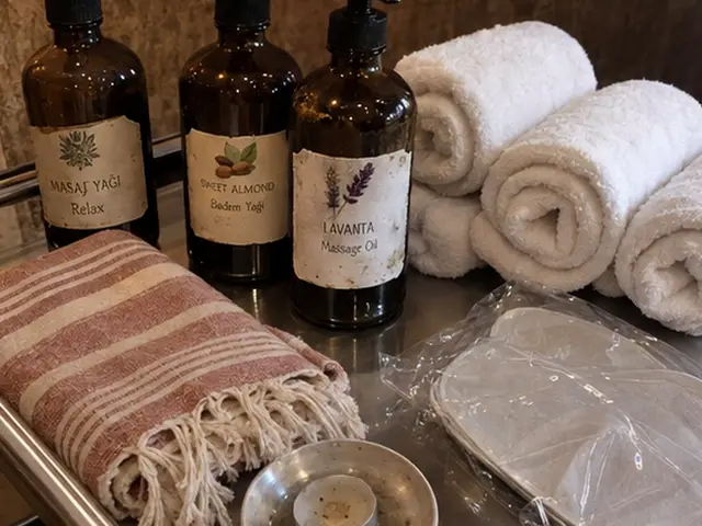 Masaj yağı şişeleri, rulo havlular ve pembe peştemal — İkitelli, Masaj Salonun